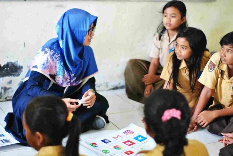 Female teacher leading a small-group discussion with students seated around a table
